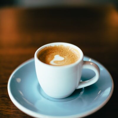 White ceramic mug of espresso on a pale blue saucer