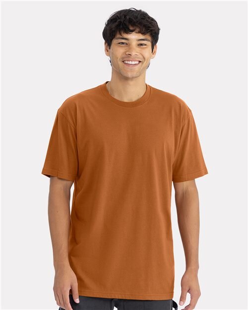 Model wearing a blank burnt-orange Next Level 3600 t-shirt
